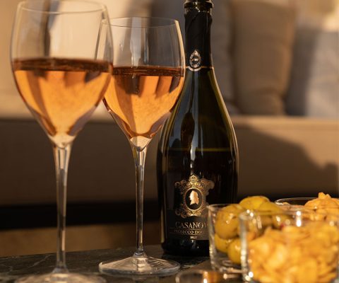 Two glasses and a bottle of Casanova Prosecco Rosé with snacks during aperitive
